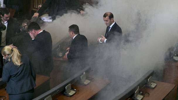 Lawmakers react as opposition lawmakers release tear gas canisters disrupting a parliamentary session in Kosovo capital Pristina on Monday Dec. 14 2015. Opposition lawmakers have released tear gas in Kosovos parliament in their latest attempt to pressure