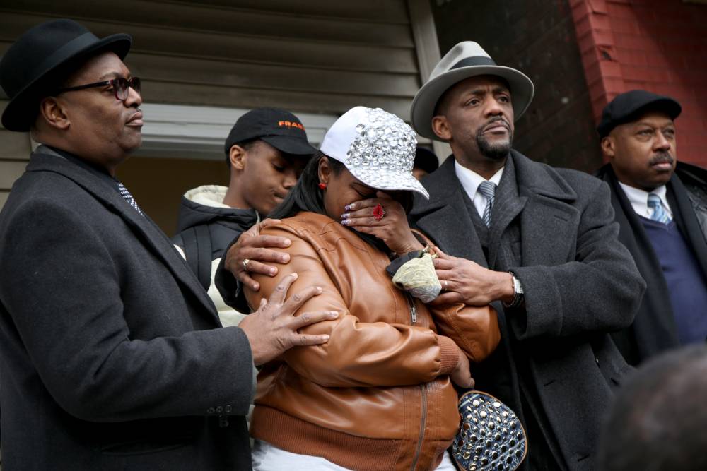 LaTarsha Jones center the daughter of Bettie Jones is comforted by family and friends during a press conference on Sunday Dec. 27 2015 in front of the house where Bettie Jones was killed Saturday in the West Garfield Park neighborhood of Chicago. Gr