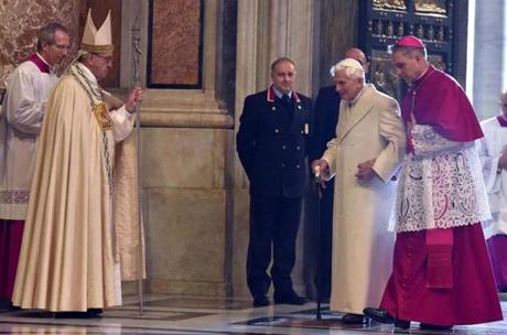 Pope Francis watched Tuesday as Pope Emeritus Benedict XVI accompanied by German Archbishop Georg Gaenswein entered St. Peter’s Basilica through the Holy Door