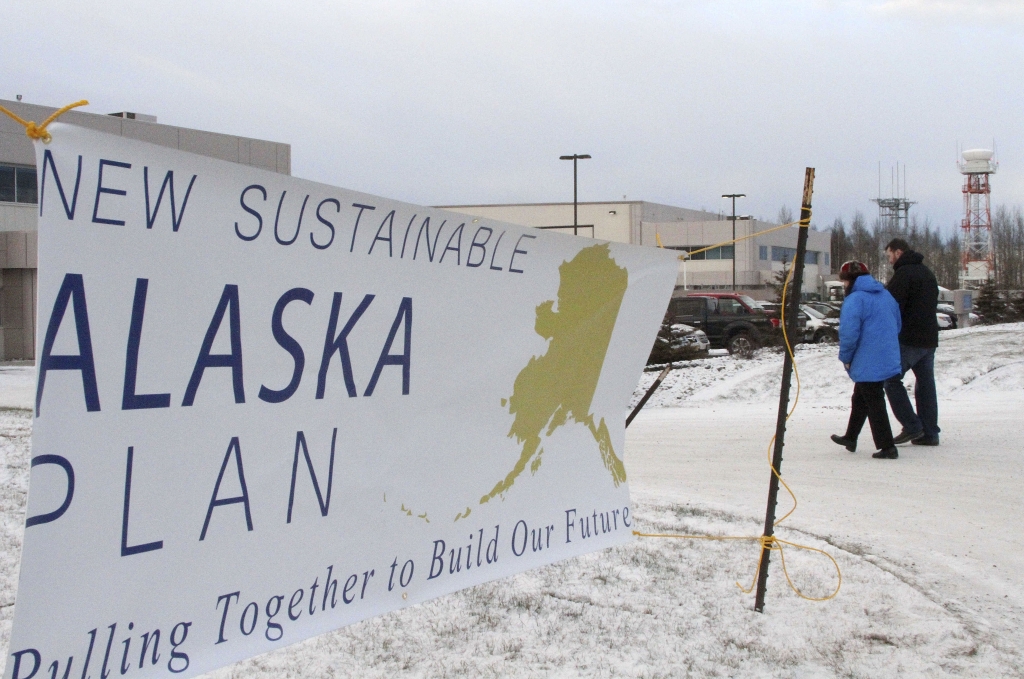 Alaska Budget Two people walk past a sign heading into a news conference held by Alaska Gov. Bill Walker on Wednesday Dec. 9 2015 in Anchorage Alaska. Walker unveiled his plan to close a $3.5 billion gap in the state budget including instituting a