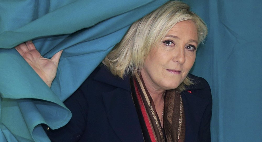 Marine Le Pen French National Front political party leader and candidate for the National Front in the Nord-Pas-de-Calais-Picardie region leaves the polling booth to cast her ballot in the second-round regional elections in Henin-Beaumont France Decem