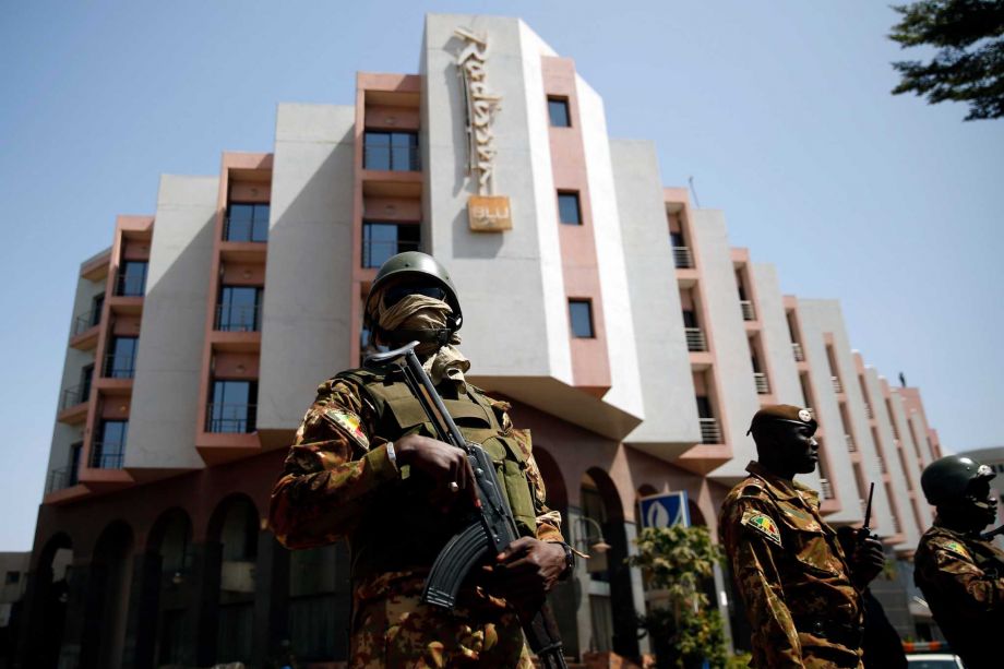 Tight security surrounds Malian President Ibrahim Boubacar Keita as he visits the Radisson Blu hotel on Saturday. A terrorist group linked to al Qaida Africa claimed responsibility for the attack