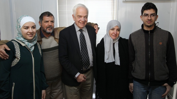 Immigration Minister John McCallum centre with a Syrian family soon to be resettled in Canada. As Syrian this family will be exempt from paying back interest-bearing government loans — unlike other refugees