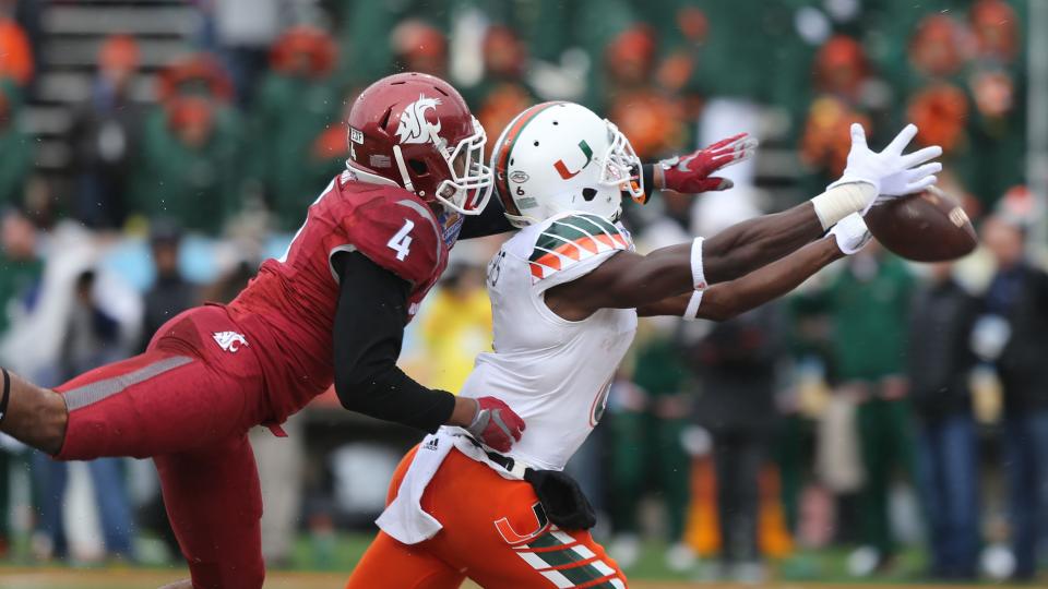 Miami receiver Herb Waters stretches to reach a long pass in front of Washington State defender Charleston White during the first half of the Sun Bowl NCAA college football game Saturday Dec. 26 2015 in El Paso Texas