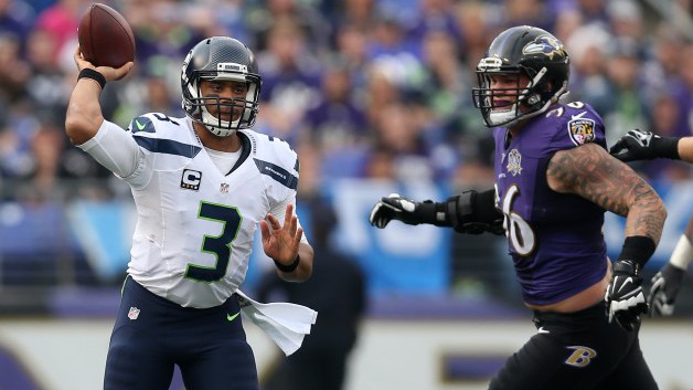 BALTIMORE MD- DECEMBER 13 Quarterback Russell Wilson #3 of the Seattle Seahawks passes the ball while under pressure by defensive end Brent Urban #96 of the Baltimore Ravens in the third quarter at M&T Bank Stadium