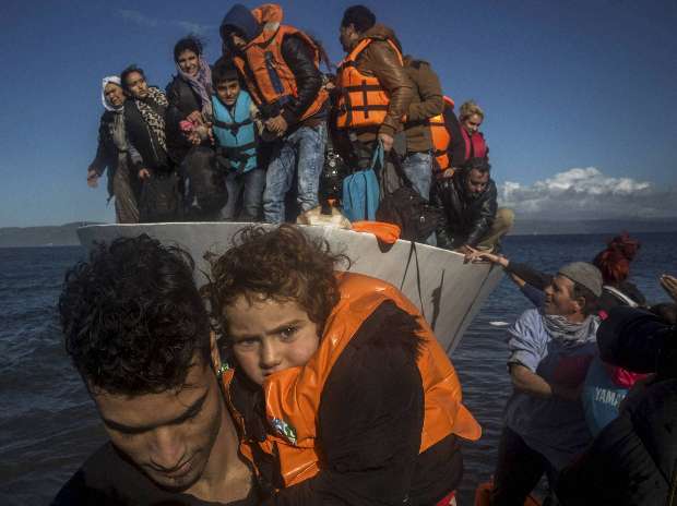 Migrants and refugees disembark from a vessel after their arrival from the Turkish coast to the northeastern Greek island of Lesbos