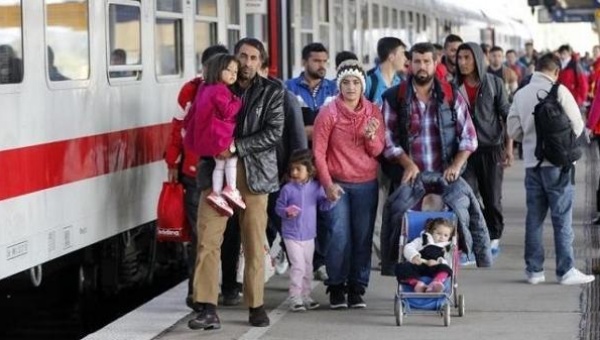 Migrants from Syria walk along a platform after arriving from Salzburg Austria at Schoenefeld railway station in Berlin Germany