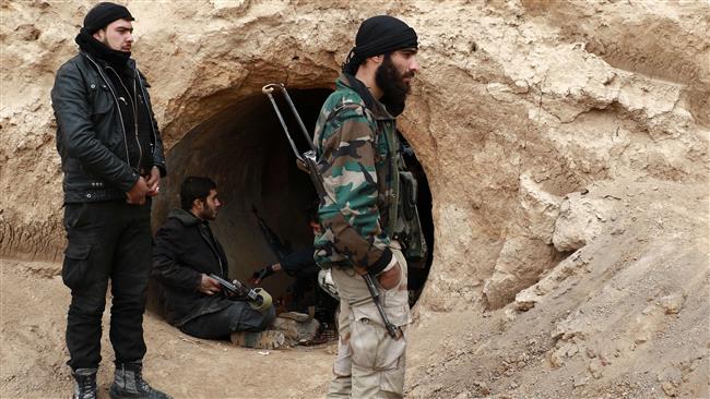 Militants wait in a concrete pipe on the outskirts of the Syrian capital Damascus