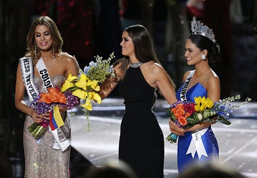 Former Miss Universe Paulina Vega center takes away the flowers and sash from Miss Colombia Ariadna Gutierrez left before giving them to Miss Philippines Pia Alonzo Wurtzbach right at the Miss Universe pageant on Sunday Dec. 20 2015 in Las Vegas