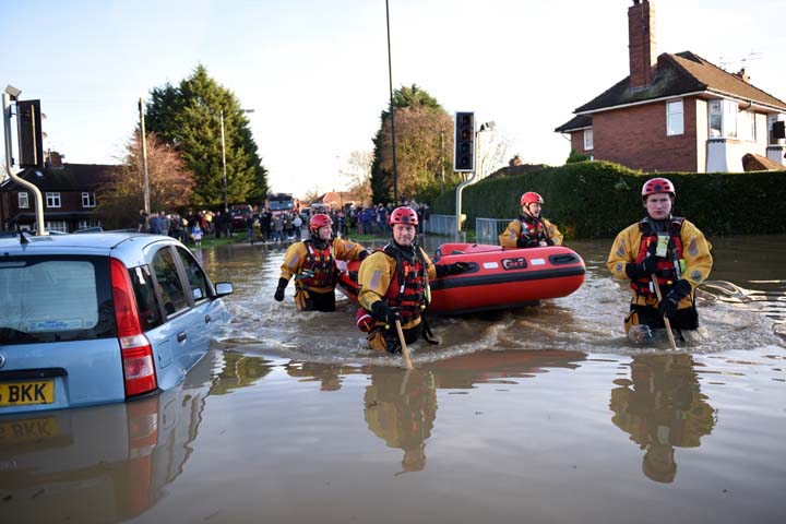 Members of the emergency services search for residents in need of rescue after the adjacent River Foss burst its banks in York northern England