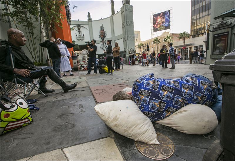 'Star Wars fans Deuce Wayne from Virginia left and Larry Ross from La Crescenta Calif. right rest while waiting in line up outside the TCL Chinese Theater Imax for the'Star Wars The Force Awakens premiere in Los Angeles