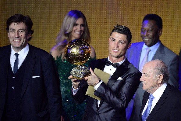 Real Madrid's Portuguese forward Cristiano Ronaldo poses with the 2013 FIFA Ballon d'Or award for player of the year next to FIFA president Sepp Blatter