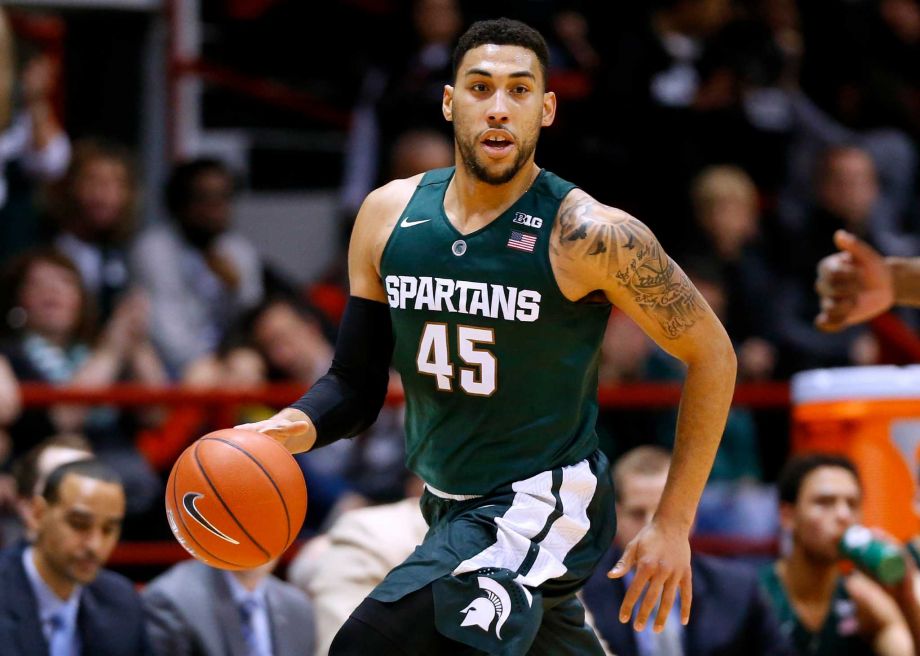 Michigan State's Denzel Valentine brings the ball upcourt during the first half of an NCAA college basketball game against Northeastern in Boston. Valentine will be out for two to three weeks with a knee injury. C