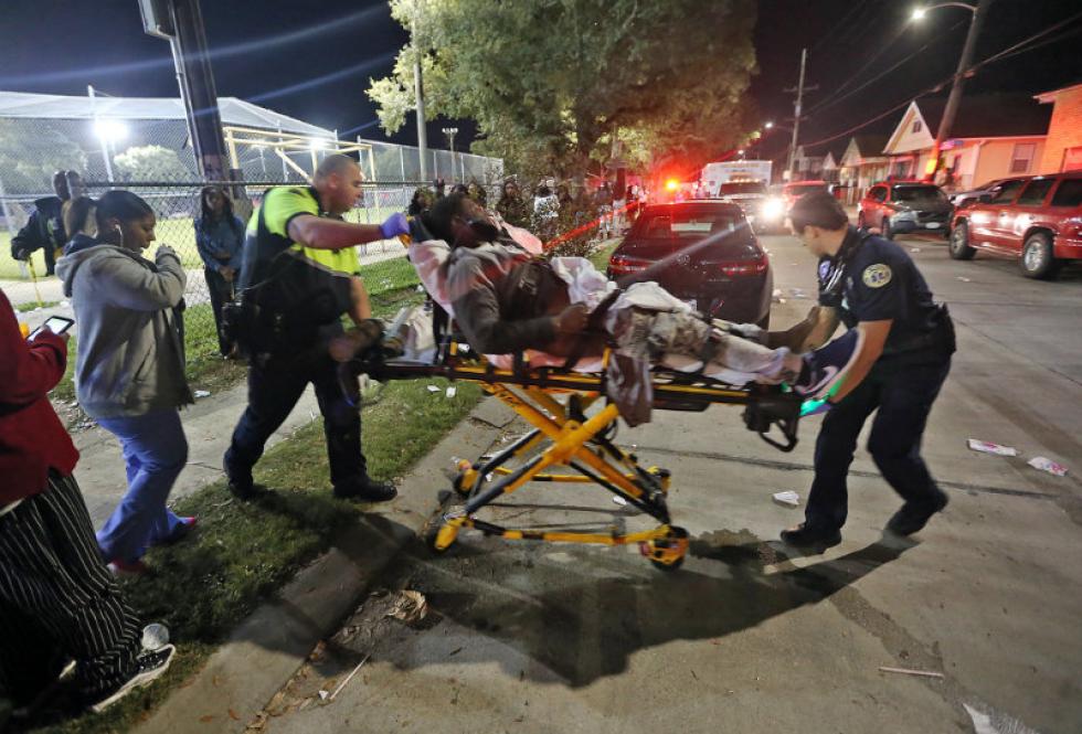 Associated Press
Officials remove a man Sunday from the scene following a shooting in New Orleans 9th Ward. Police spokesman Tyler Gamble said police were on their way to break up a big crowd when gunfire erupted at Bunny Friend Park