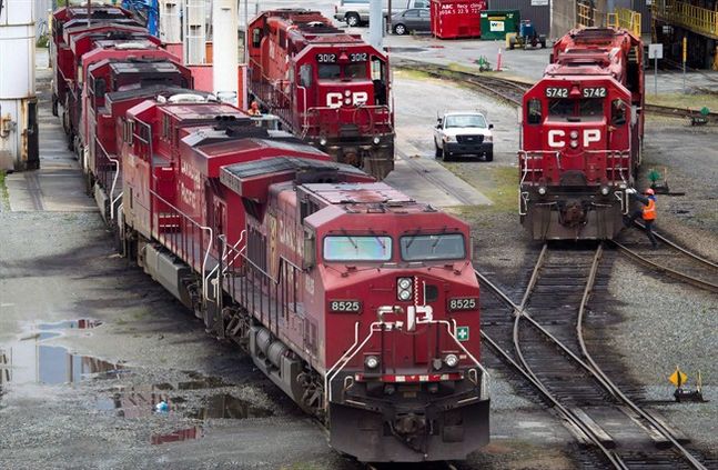 A Canadian Pacific Rail maintenance worker climbs onto a locomotive at the company's Port Coquitlam yard east of Vancouver B.C. on Wednesday