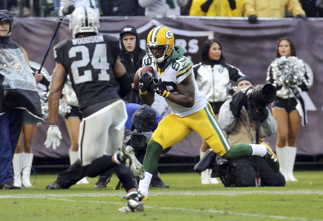 ASSOCIATED PRESS           Green Bay Packers wide receiver James Jones catches a touchdown pass next to Oakland Raiders free safety Charles Woodson during the second half of an NFL football game Sunday Dec. 20 2015 in O