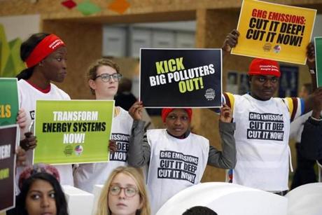 Activists protesting against polluters held banners at the Climate Generations Areas as part of the United Nations Climate Change Conference in Le Bourget north of Paris