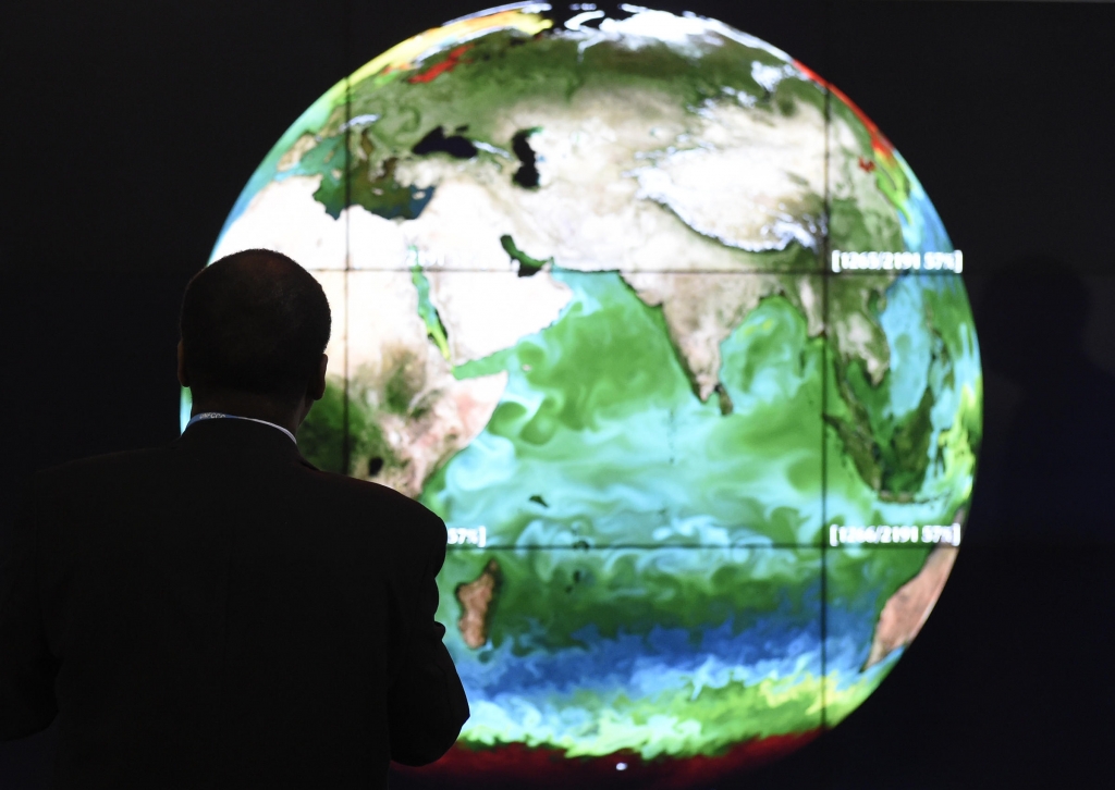 A conference attendee looks at a projection of the Earth on the opening day of the COP 21 United Nations conference on climate change on Monday in Le Bourget on the outskirts of Paris