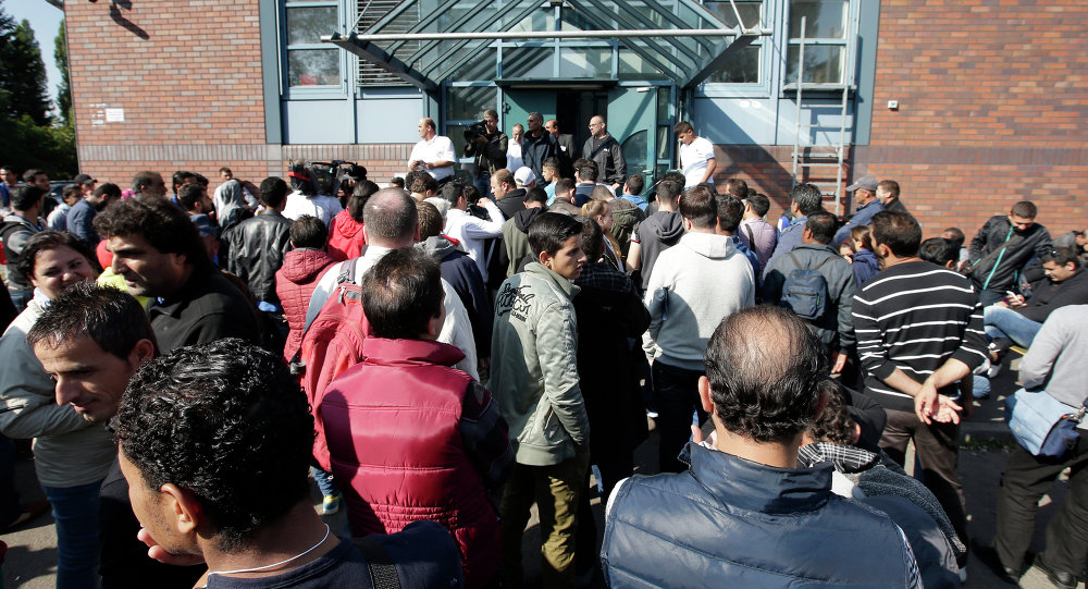 People wait outside a registration center for migrants and refugees in Berlin Germany Thursday Sept. 10 2015