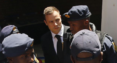 South African Olympic and Paralympic sprinter Oscar Pistorius is escorted to a police van. The Supreme Court dismissed prosecutors attempt to change his conviction for culpable homicide to the more serious charge of murder. /Reuters