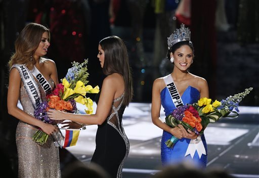 Former Miss Universe Paulina Vega center takes away the flowers and sash from Miss Colombia Ariadna Gutierrez left before giving it to Miss Philippines Pia Alonzo Wurtzbach right at the Miss Universe pageant Sunday Dec. 20 2015 in Las Vegas. Acco