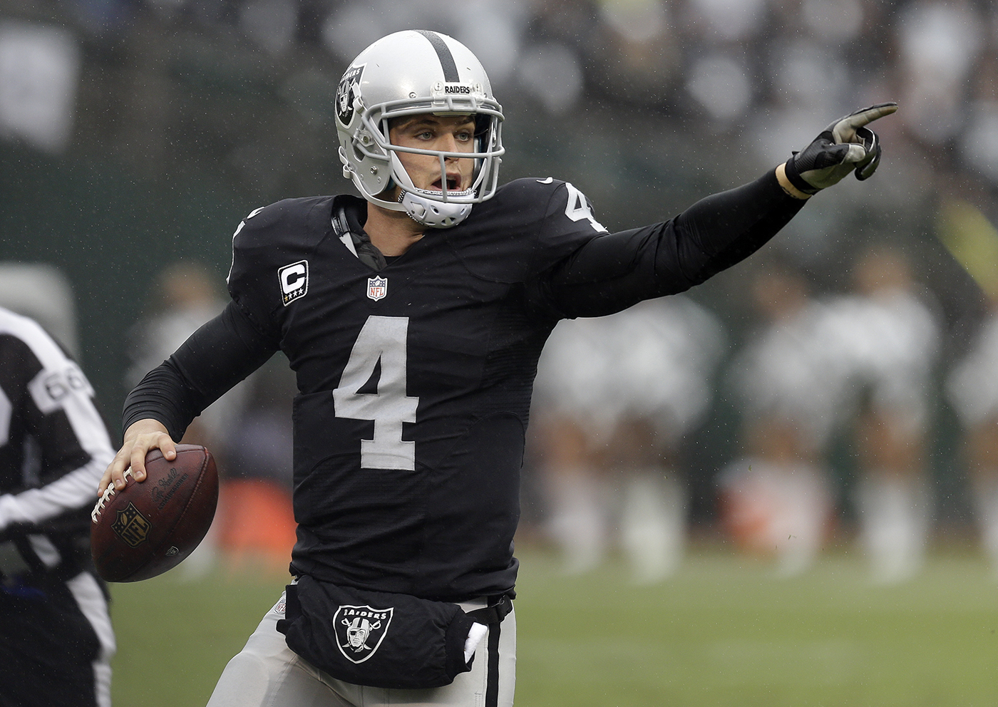 Raiders quarterback Derek Carr directs his team as he rolls out against the Green Bay Packers during the game on Sunday in Oakland