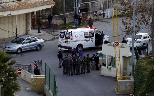 Israeli border policemen stand guard near the scene where a Palestinian man stabbed and critically wounded an Israeli before being shot dead by Israeli forces in the West Bank city of Hebr