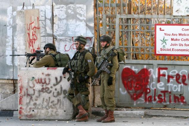 An Israeli soldier takes aim during clashes with Palestinian protesters at the main entrance of the West Bank city of Bethlehem on Dec. 25. New violence erupted in the West Bank the day before with four Palestinian attackers shot dead by Israeli forces