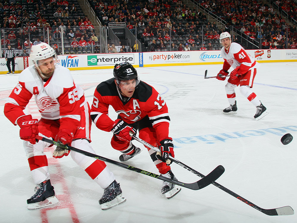 Mike Cammalleri #13 of the New Jersey Devils and Niklas Kronwall #55 of the Detroit Red Wings fight for the puck during the third period at the Prudential Center