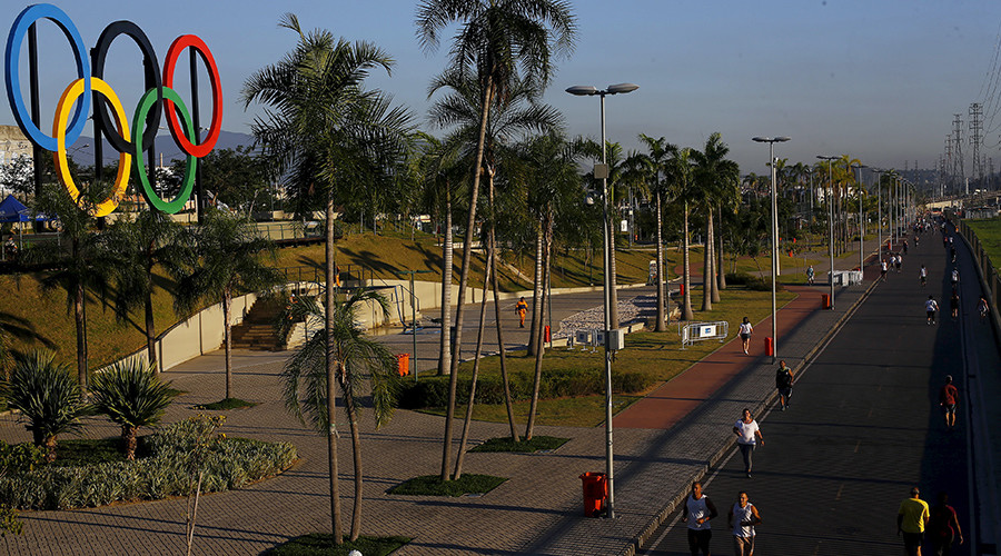 People exercise next to the Olympic rings placed at the Madureira Park ahead the Rio 2016 Olympic Games in Rio de Janeiro