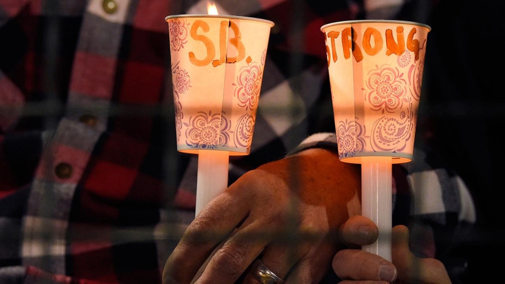 People hold candles during a vigil for shooting victims on Thursday Dec. 3 2015 at San Manuel Stadium in San Bernardino Calif