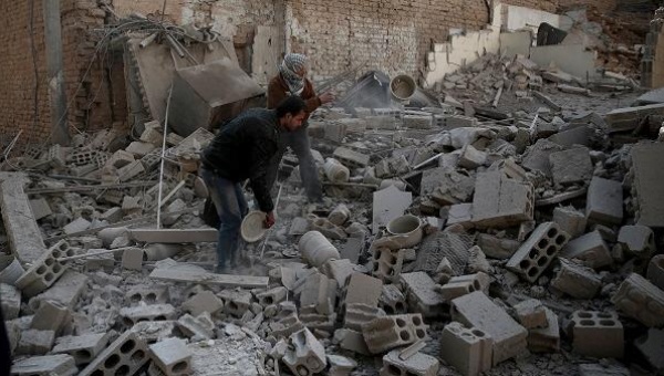 People search for belongings at a site hit by missiles in the Douma neighborhood of Damascus Syria