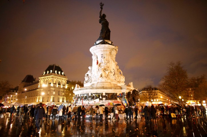 People share a quiet moment in in tribute to victims of the attacks at the Place de la Republique in Paris. REUTERS  Charles Platiau