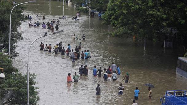 People wade through a flooded road in Chennai Tamil Nadu India