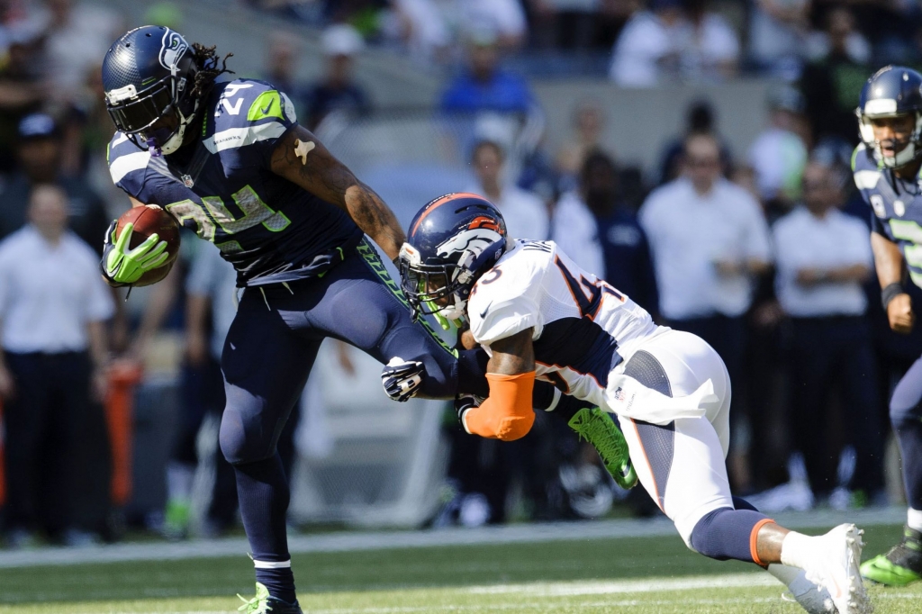 Marshawn Lynch defending TJ Ward's single leg takedown attempt- Steven Bisig-USA TODAY Sports