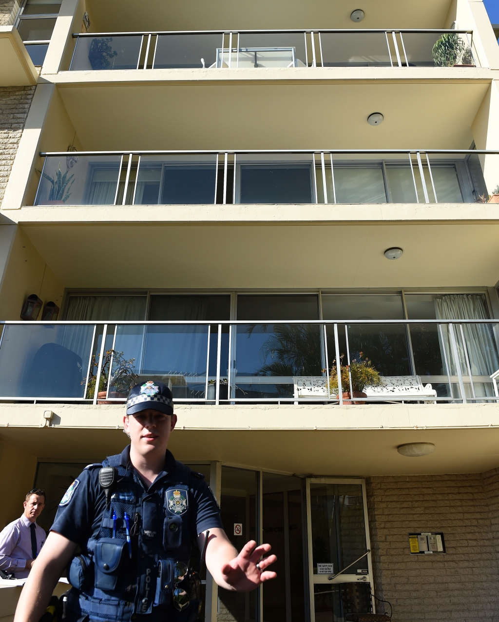 Police guard the entrance to a high-rise complex where the body of an 11-year-old girl was found in Auchenflower Brisbane