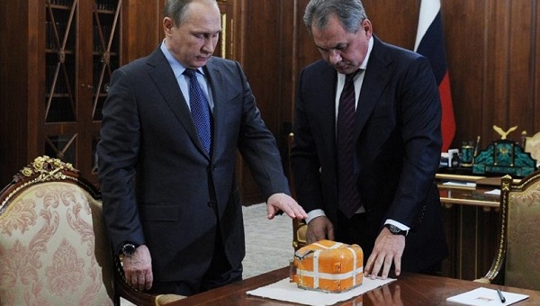 Russian President Vladimir Putin and Defence Minister Sergei Shoigu examine the flight recorder from the Russian Sukhoi Su-24 bomber shot down by a Turkish jet Dec. 8 2015