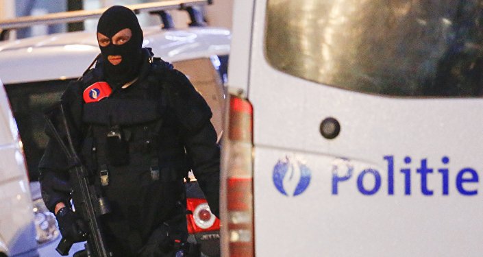 A Belgian special forces police officer patrols a street during a police raid in central Brussels Belgium