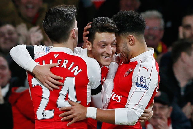 REUTERS    
     ALL GUNS BLAZING Ozil is mobbed by his team-mates