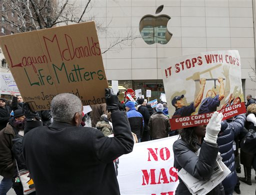 Protesters try to block the entrance to the Apple Store on Chicago's Magnificent Mile calling for the resignation of Mayor Rahm Emanuel Thursday Dec. 24 2015 in Chicago. The Christmas Eve protest is the latest in a series of demonstrations in