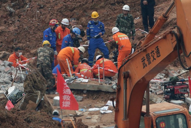 Rescuers try to get into a buried building to search for potential survivors of the landslide