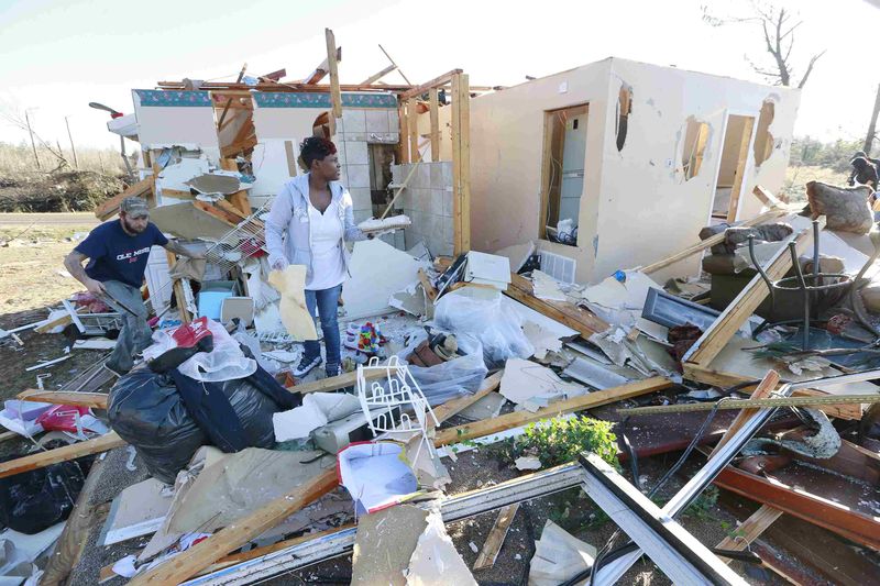 Residents salvage what they can from their home along Highway 178 after a tornado struck Holly Springs Mississippi. – Reuters pic