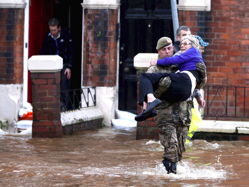 ReutersA soldier carries a woman from a flooded house on a residential street in Carlisle Britain