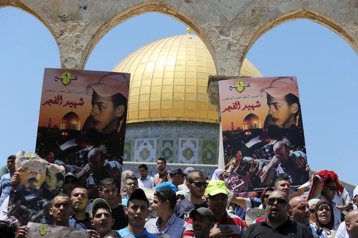 ReutersPalestinian protesters hold placards depicting Mohammed Abu Khudair during a protest marking the anniversary of his killing