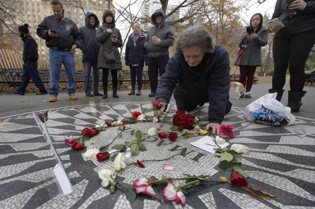 Billy Ogansanti arranges flowers on the “Imagine” mosaic in remembrance of John Lennon on the 35th anniversary of his murder