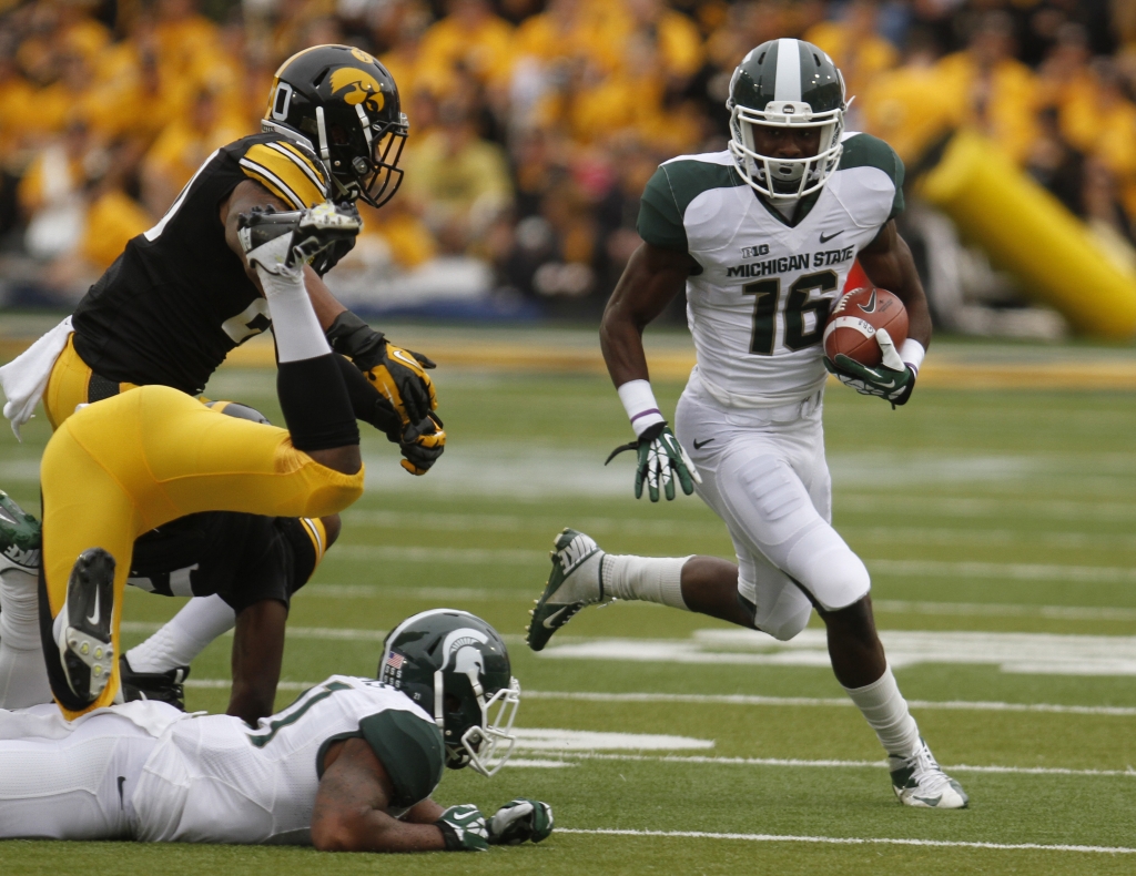 Wide receiver Aaron Burbridge #16 of the Michigan State Spartans rushes up field during the first quarter in front of linebacker Christian Kirksey #20 of the Iowa Hawkeyes