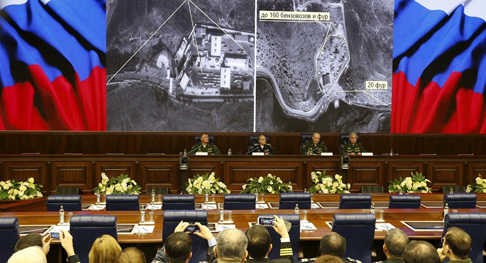 Defence ministry officials sit under screens with satellite images on display during a briefing in Moscow Russia