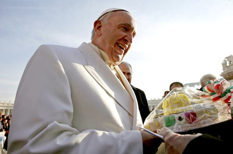 Pope Francis receives a cake as he arrives to lead the weekly audience in Saint Peter’s square at the Vatican December 16