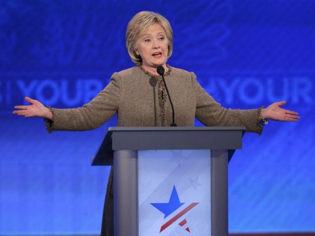 Democratic US presidential candidate Hillary Clinton reacts as she reaches her podium after she failed to return from a break in time for the resumption of discussions at the Democratic presidential candidates debate at St Anselm College in Manchester Ne