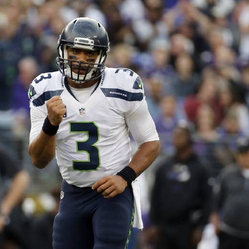 Seattle Seahawks quarterback Russell Wilson celebrates a touchdown pass to Seahawks wide receiver Doug Baldwin during the second half an NFL football game against the Baltimore Ravens Sunday Dec. 13 2015 in Baltimore